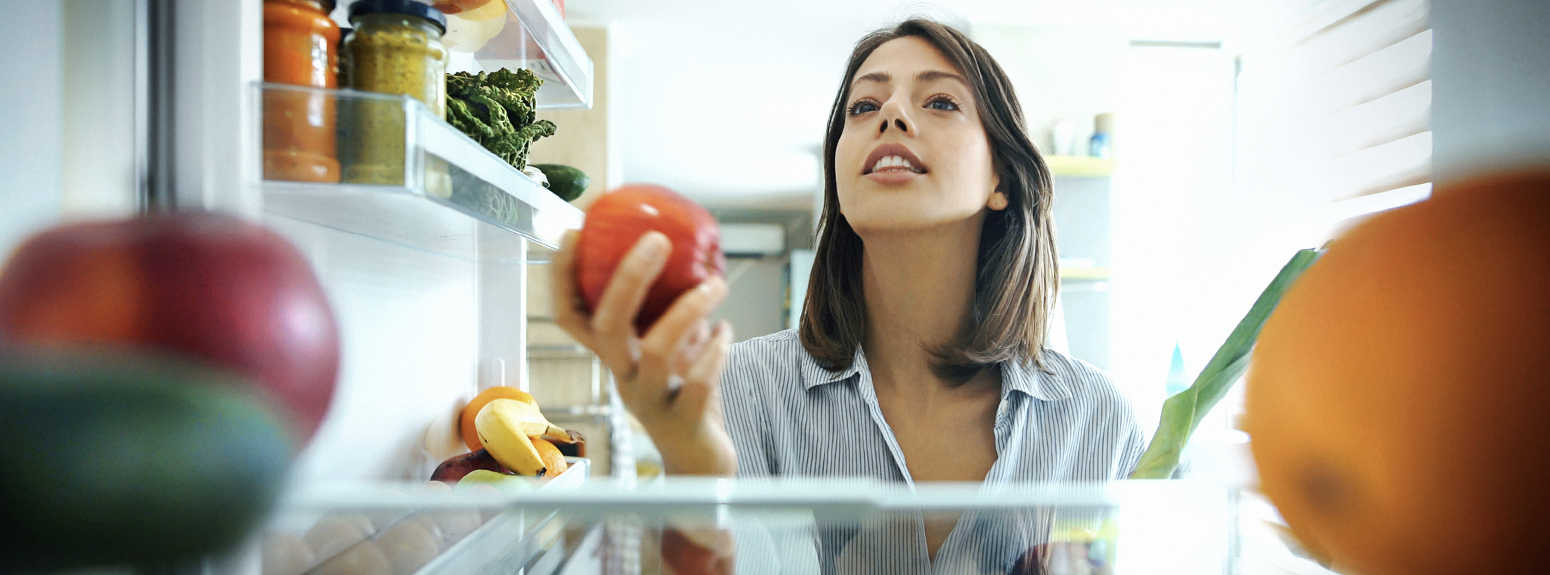 Ragazza che guarda dentro il frigo