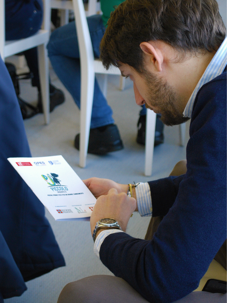 Close Up di una persona che tiene in mano la brochure del Piccolo Urbanista 2.0