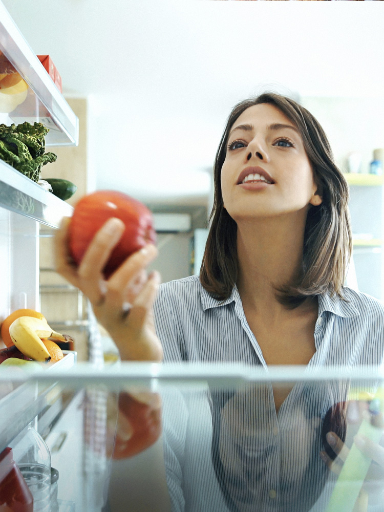 Ragazza che guarda dentro il frigo